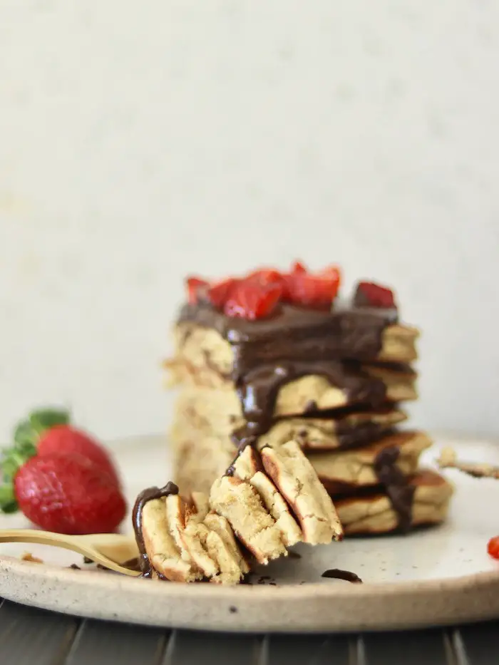 panqueca vegana doce servida com creme de avelã e chocolate caseiro e morangos frescos