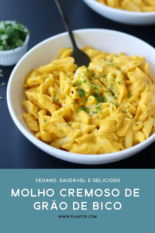 molho cremoso de grão de bico servido com macarrão do tipo penne em um prato com temperos frescos