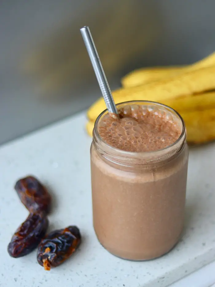 smoothie de chocolate, tâmara e amendoim vegano servido em um copo