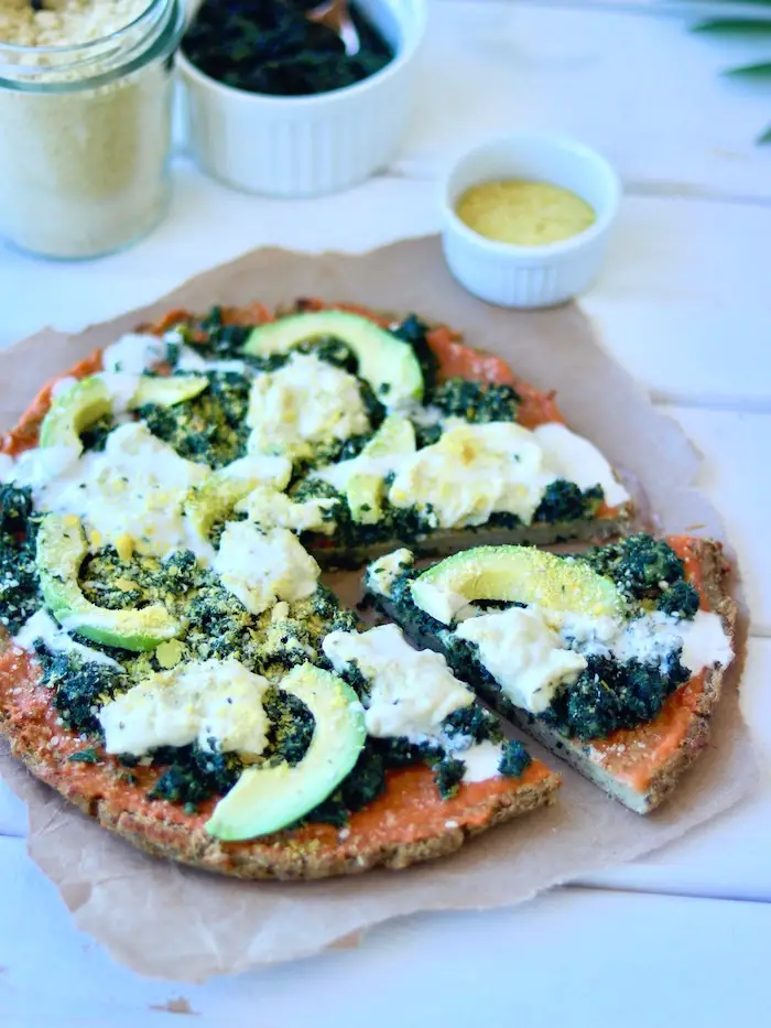 pizza vegana com massa de couve flor e creme de folhas de cenoura, com queijo cremoso vegano, avocado e parmesão vegano