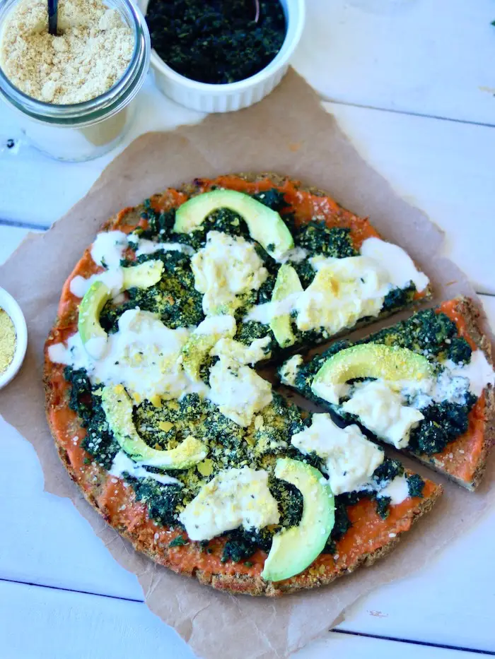 pizza vegana com massa de couve flor e creme de folhas de cenoura, queijo cremoso vegano, avocado e parmesão vegano