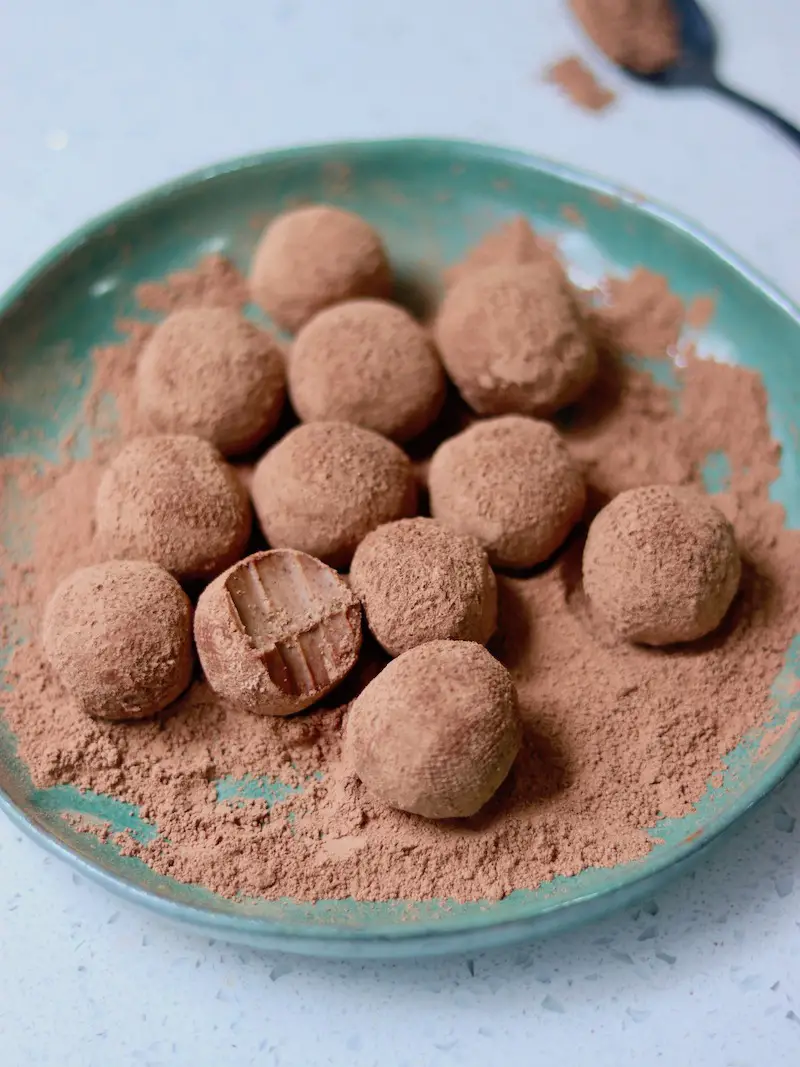 trufas veganas de nutella servidas em um prato com cacau em pó