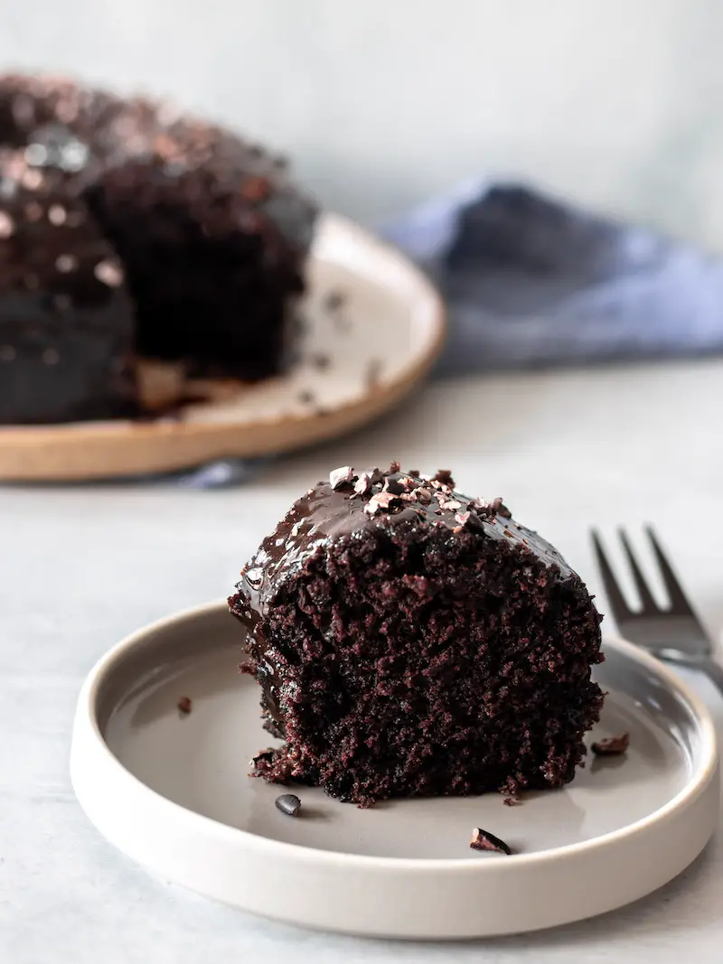 bolo de chocolate vegano simples e fofinho com calda de chocolate e nibs de cacau