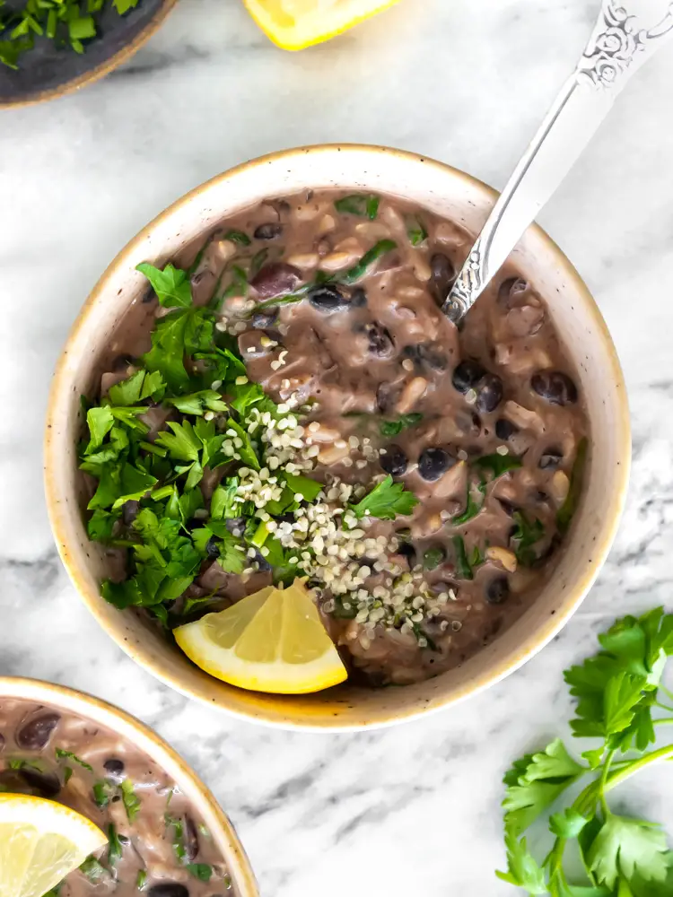 sopa de feijão com arroz e leite de coco servida com salsinha fresca picada e limão