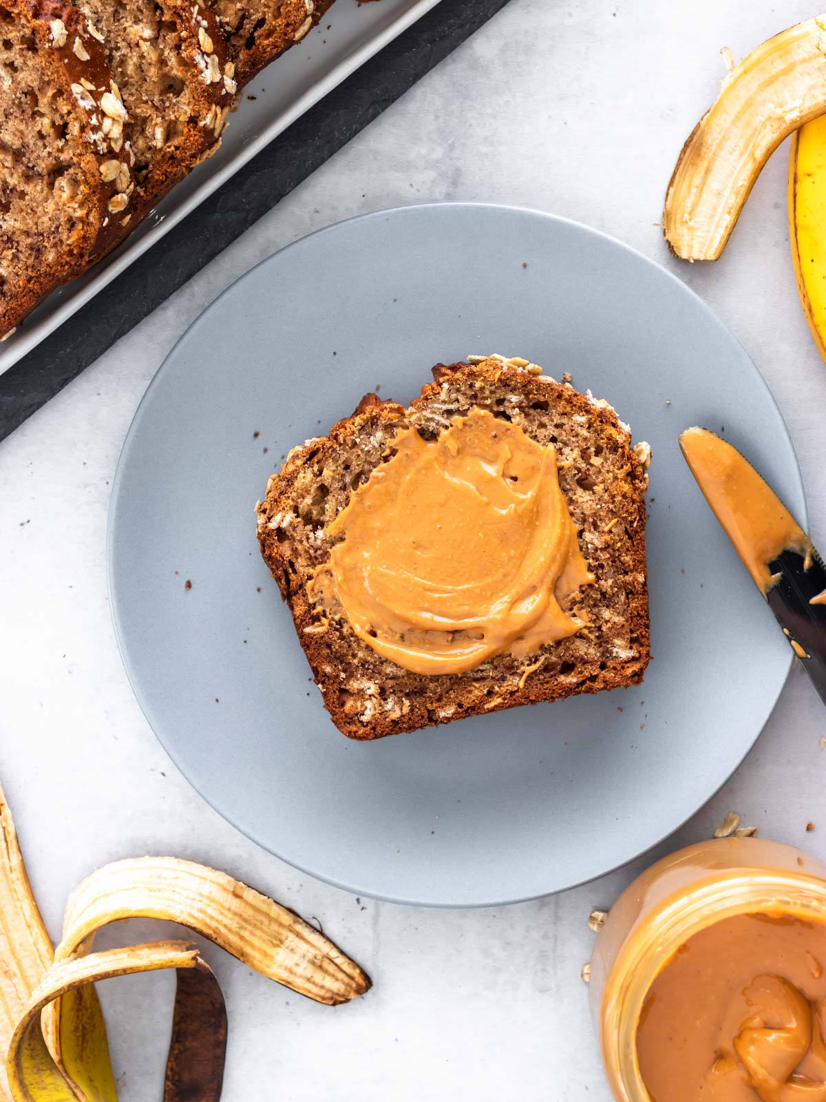 fatia de bolo de banana com aveia servida com pasta de amendoim