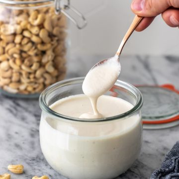 colher com creme de castanha de caju sendo retirada do pote