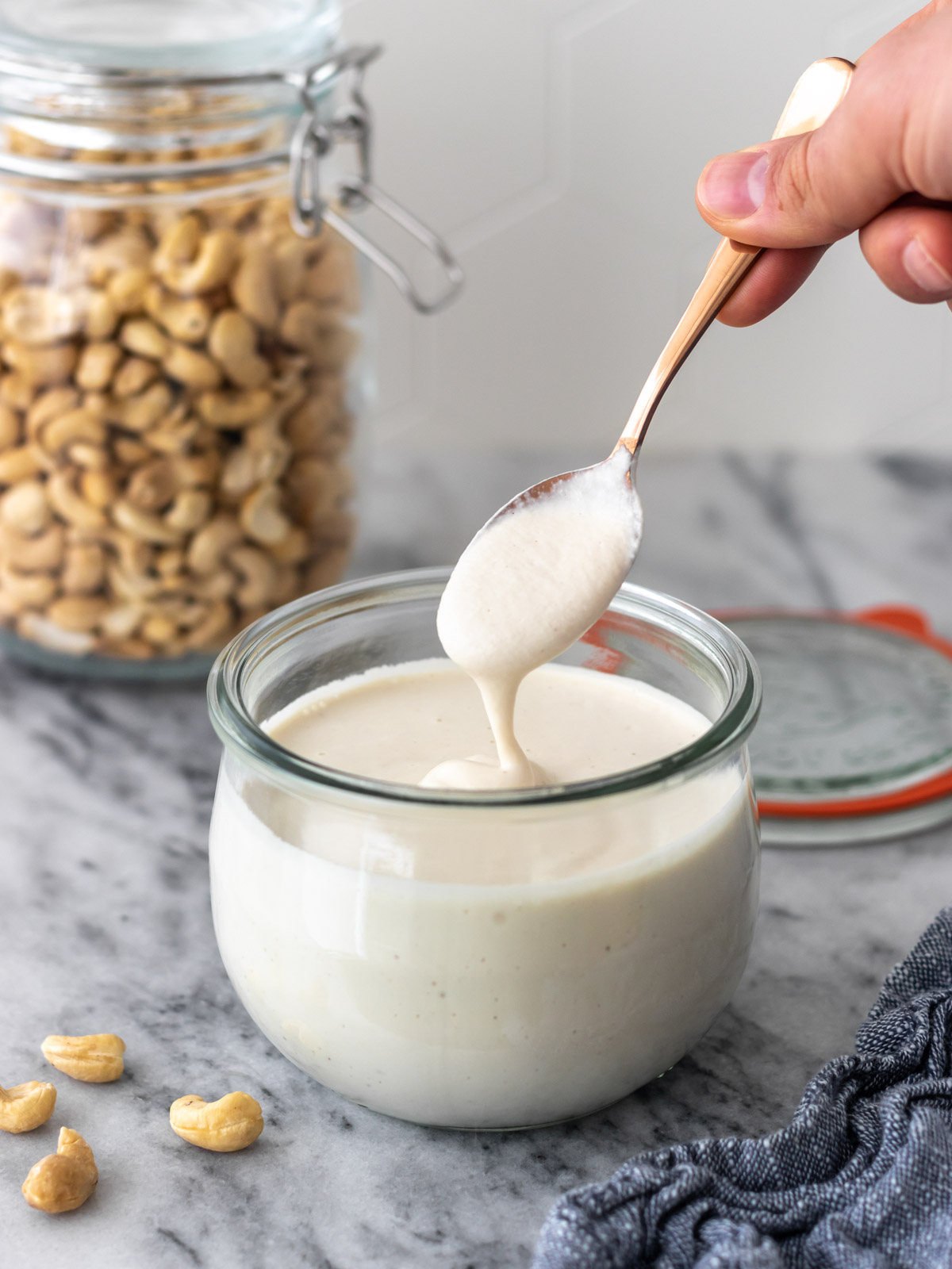 colher com creme de castanha de caju sendo retirada do pote