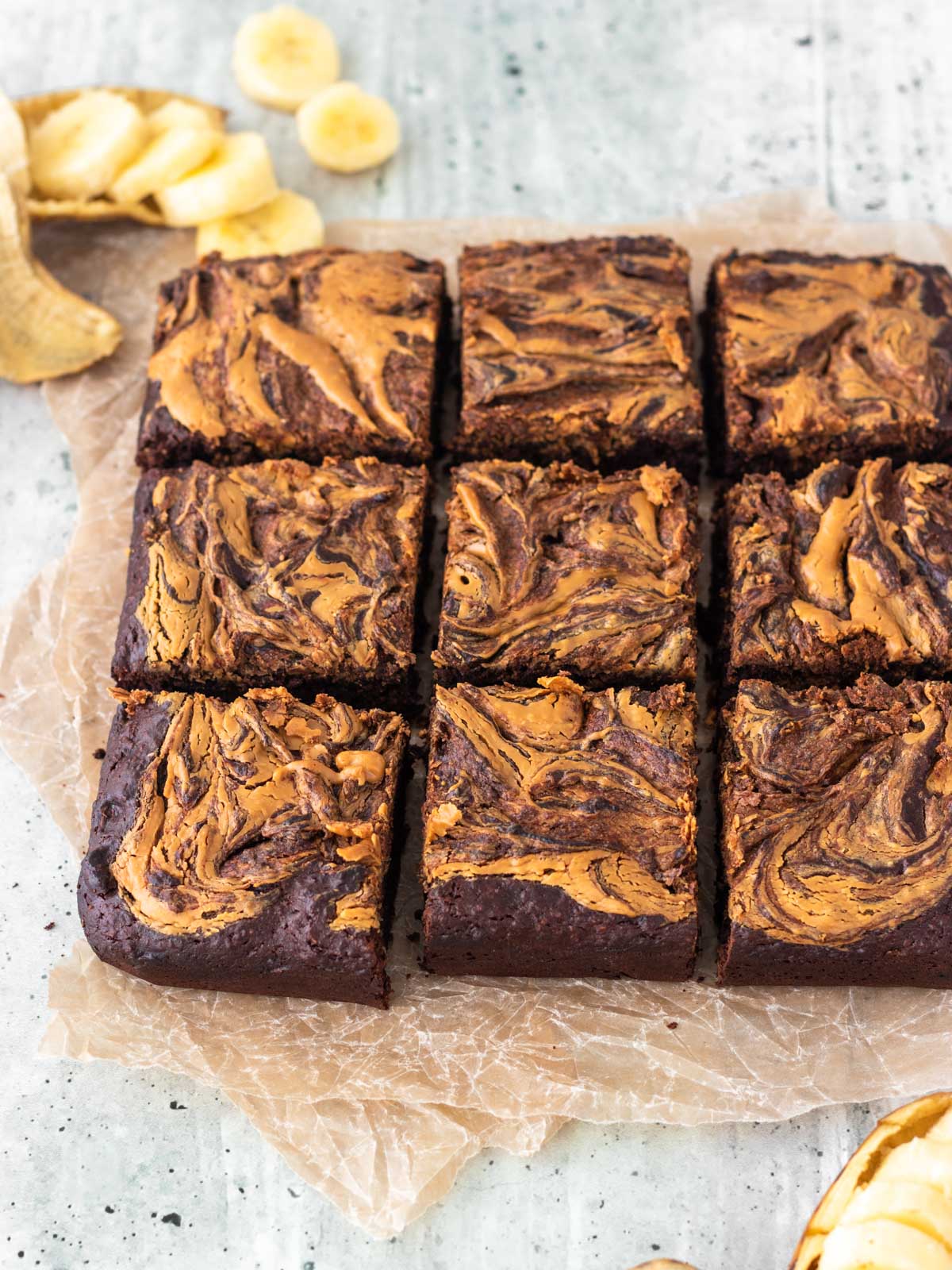 brownie de banana coberto com pasta de amendoim cortado em 9 pedaços grandes