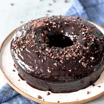 bolo de chocolate com calda brilhante de chocolate e nibs de cacau