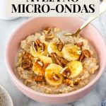 mingau de aveia servido em uma tigela com rodelas de banana, pitada de canela em pó e nozes-pecã picadas