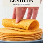 mão enrolando uma panqueca de lentilha vermelha