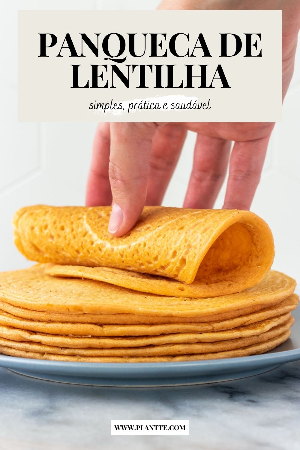 mão enrolando uma panqueca de lentilha vermelha