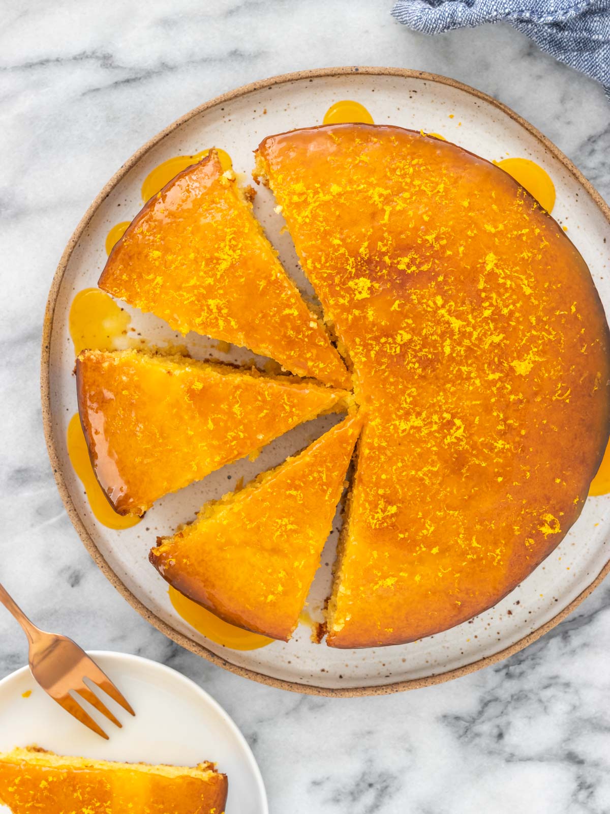 vista aérea de um bolo de laranja com calda, redondo e com 3 fatias cortadas