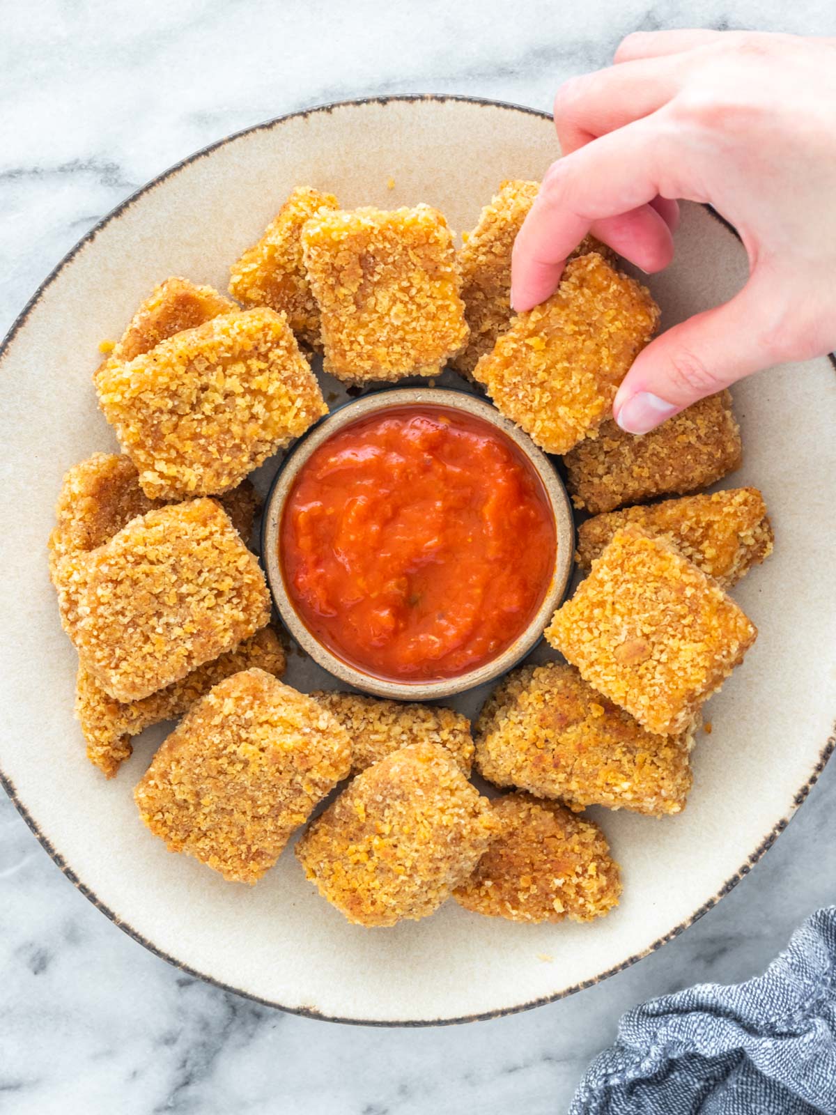 prato de Nuggets vegano com um pote de molho marinara no meio
