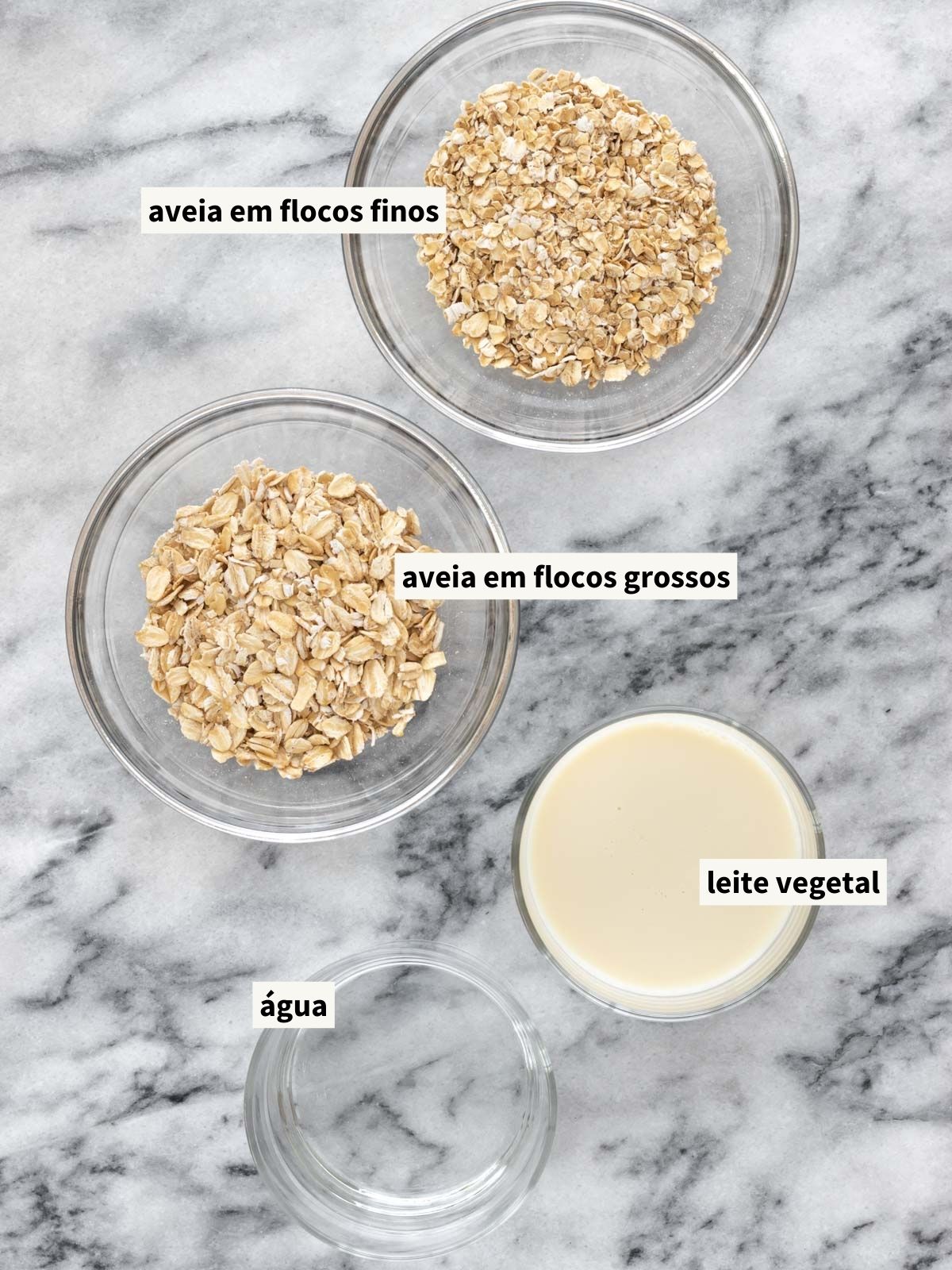 ingredientes para fazer mingau de aveia, incluindo aveia em flocos grossos, aveia em flocos finos, leite vegetal e água filtrada