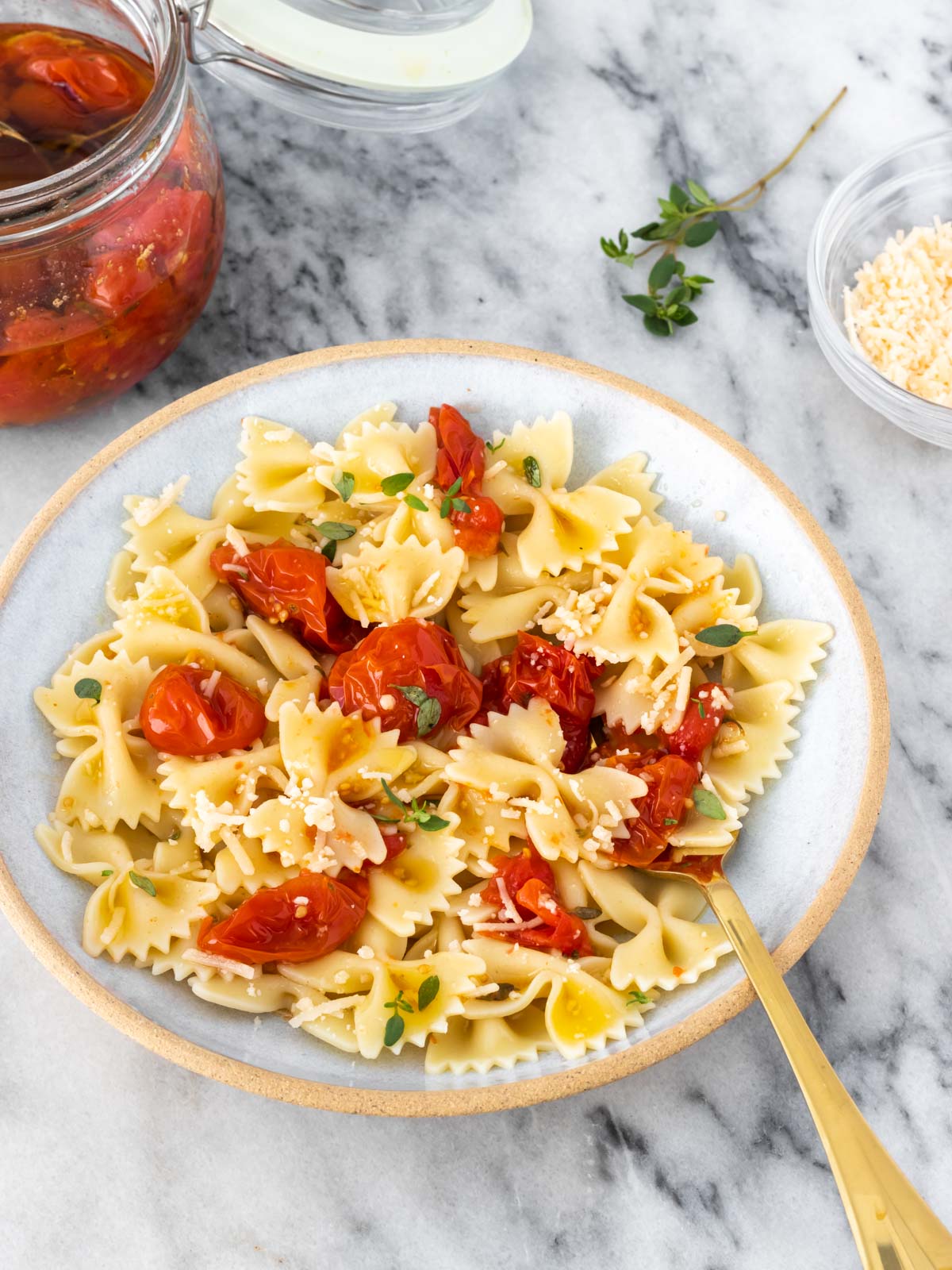 prato de macarrão farfalle servido com tomate confit e tomilho fresco