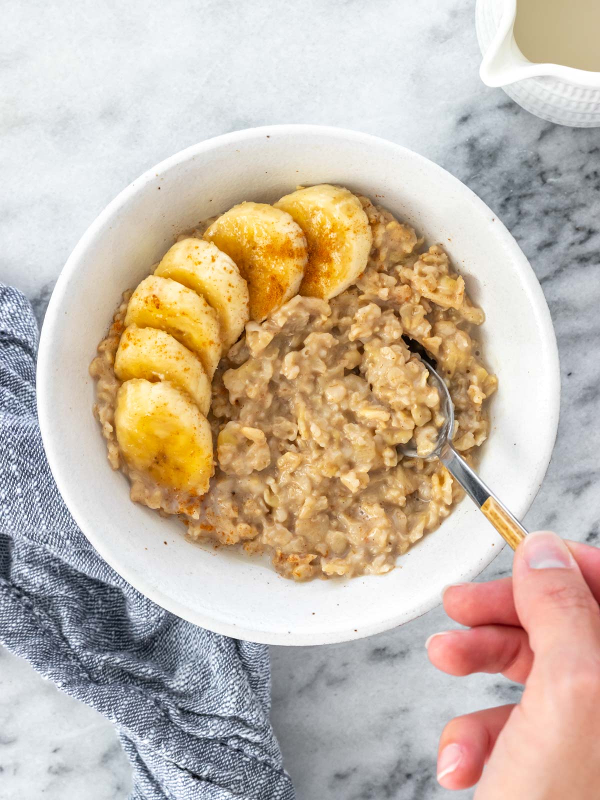 pote de mingau de aveia servido com rodelas de banana e canela