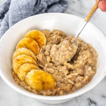 pote de mingau de aveia servido com rodelas de banana e canela