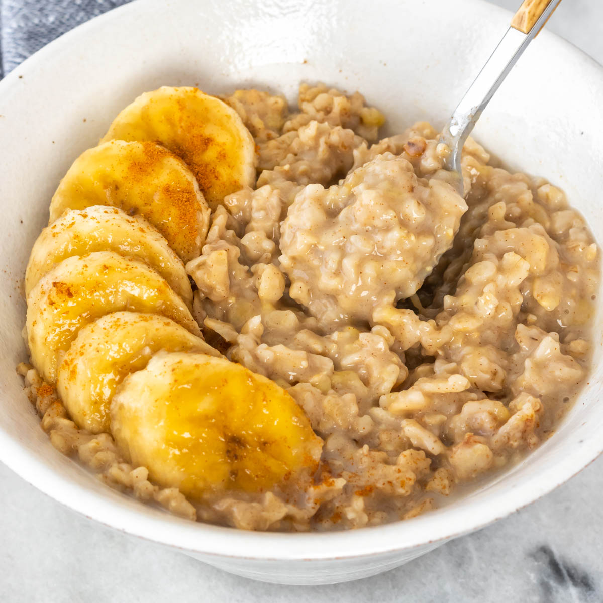pote de mingau de aveia servido com rodelas de banana e canela