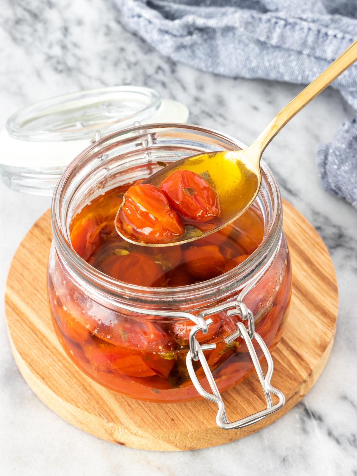 colher retirando tomate confit de pote de vidro