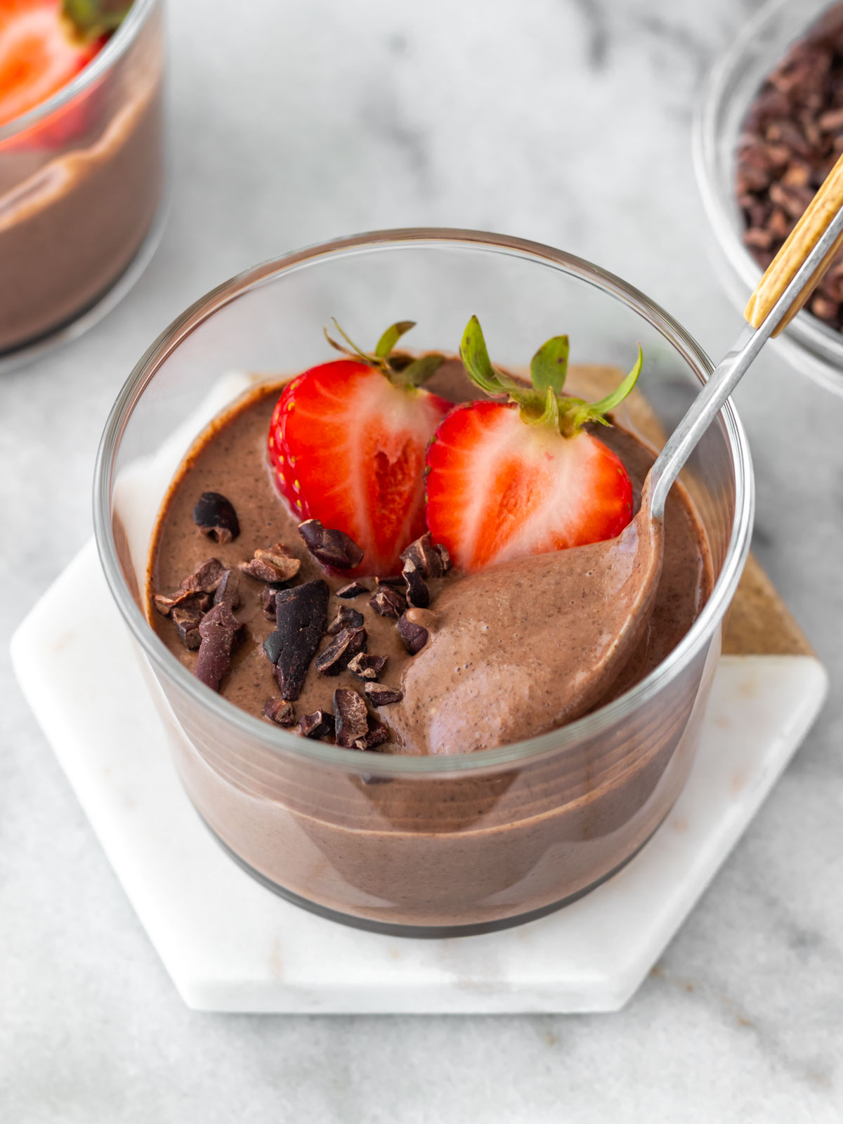 pudim de chia de chocolate batido, servido com morangos e nibs de cacau