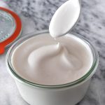 colher sendo retirada de pote de maionese de aquafaba vegana