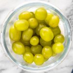 uvas lavadas dentro de um pote forrado com papel-toalha