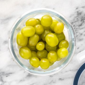 uvas lavadas dentro de um pote forrado com papel-toalha