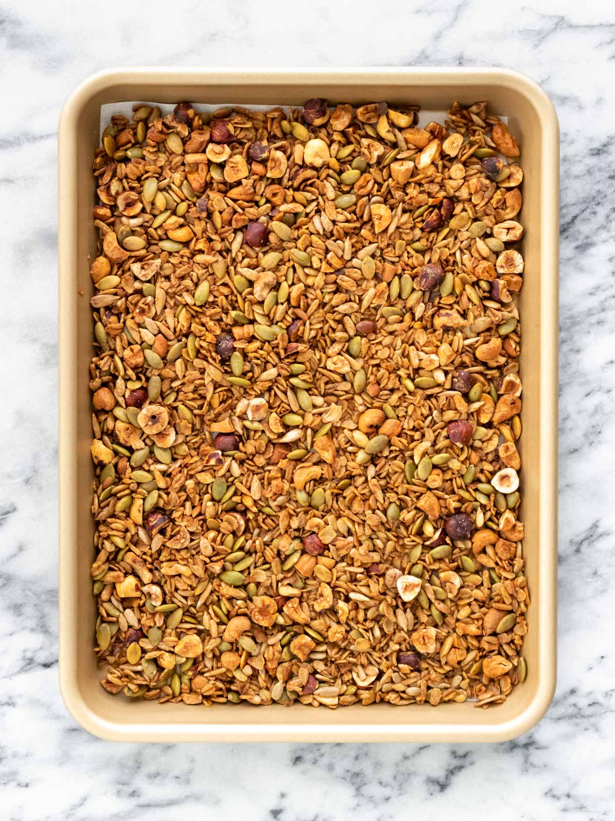 granola espalhada em uma assadeira e recém saída do forno