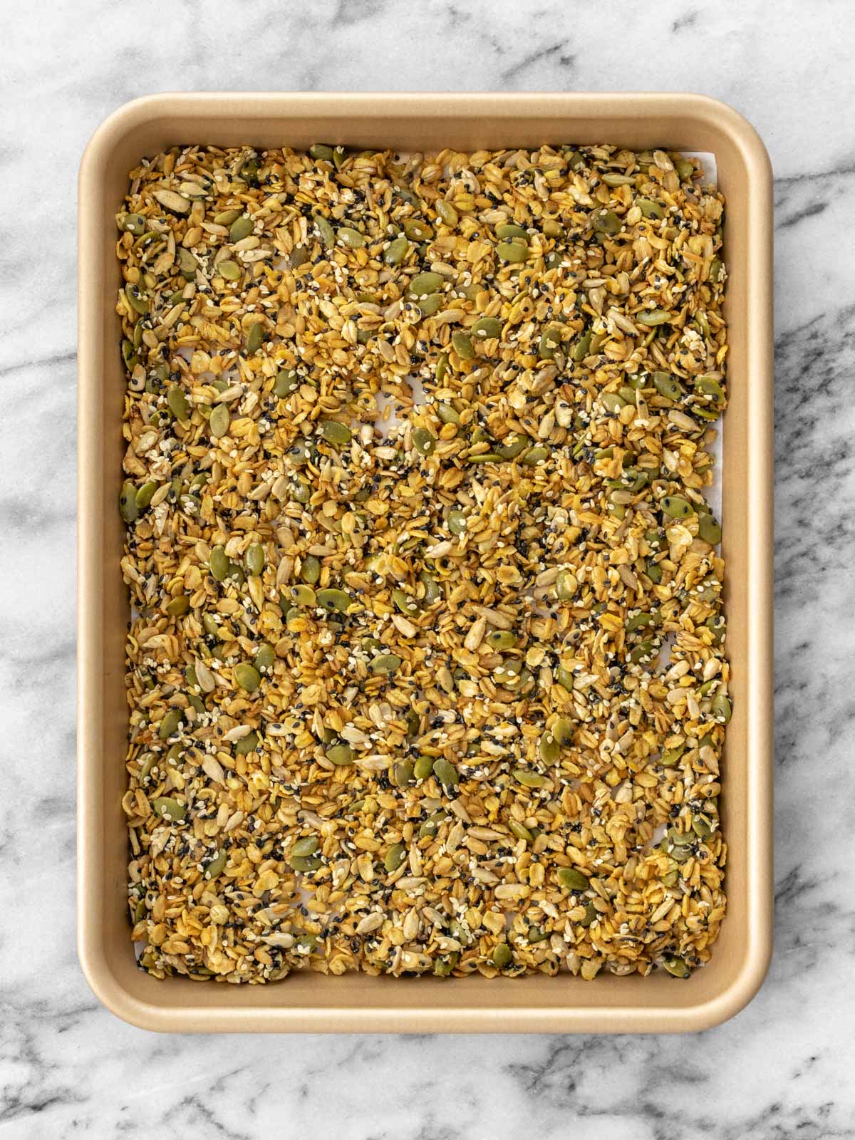 mistura de granola salgada distribuída uniformemente em uma assadeira