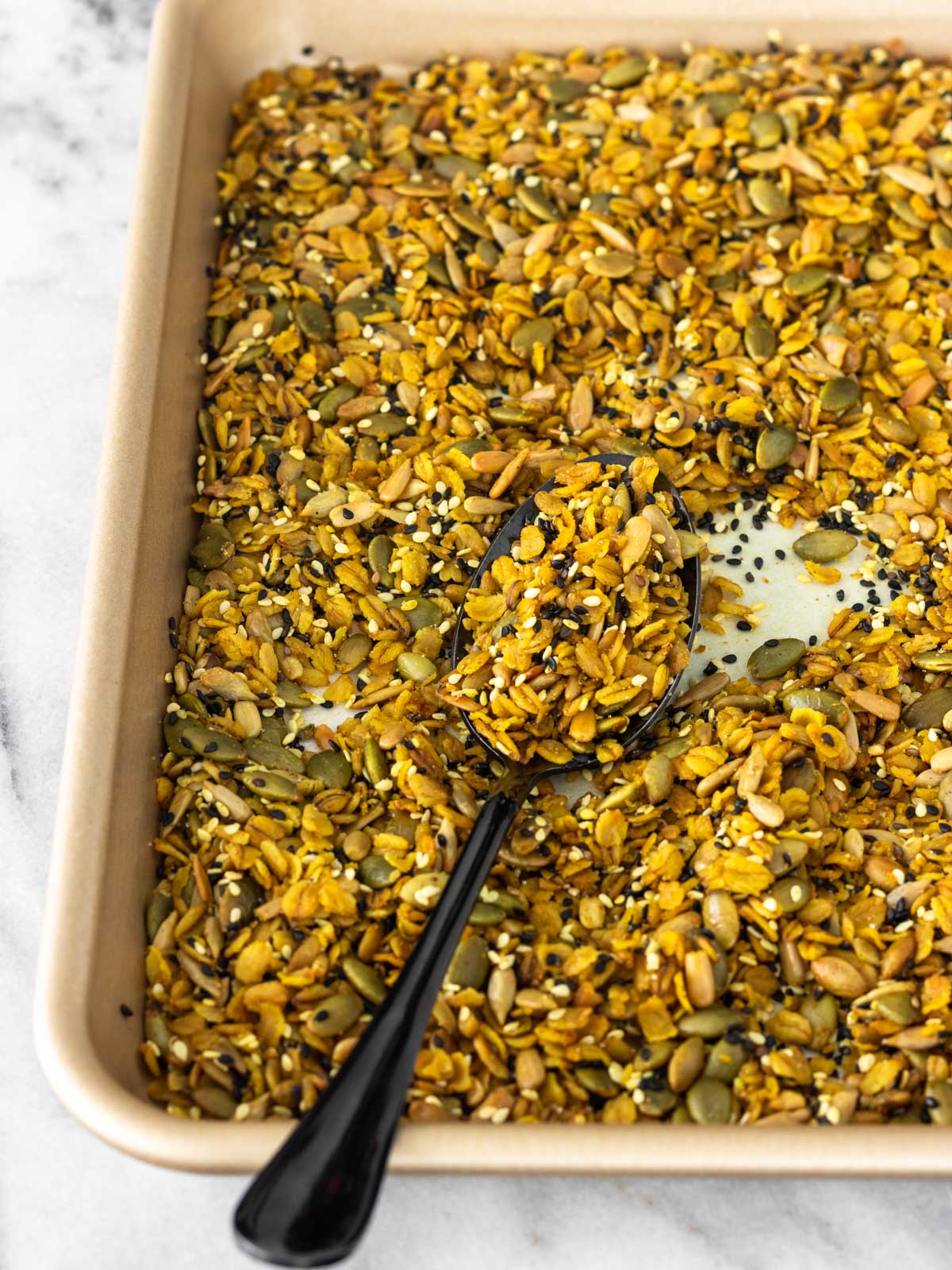 granola salgada com sementes e especiarias em assadeira, logo depois de assada