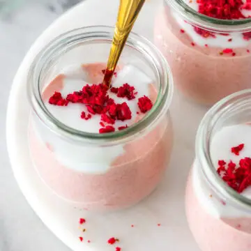 creme de aveia batido com morangos servido em um potinho com iogurte e framboesas desidratadas