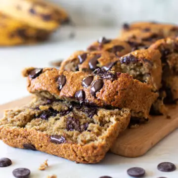bolo de banana com gotas de chocolate cortado em cima de uma tábua