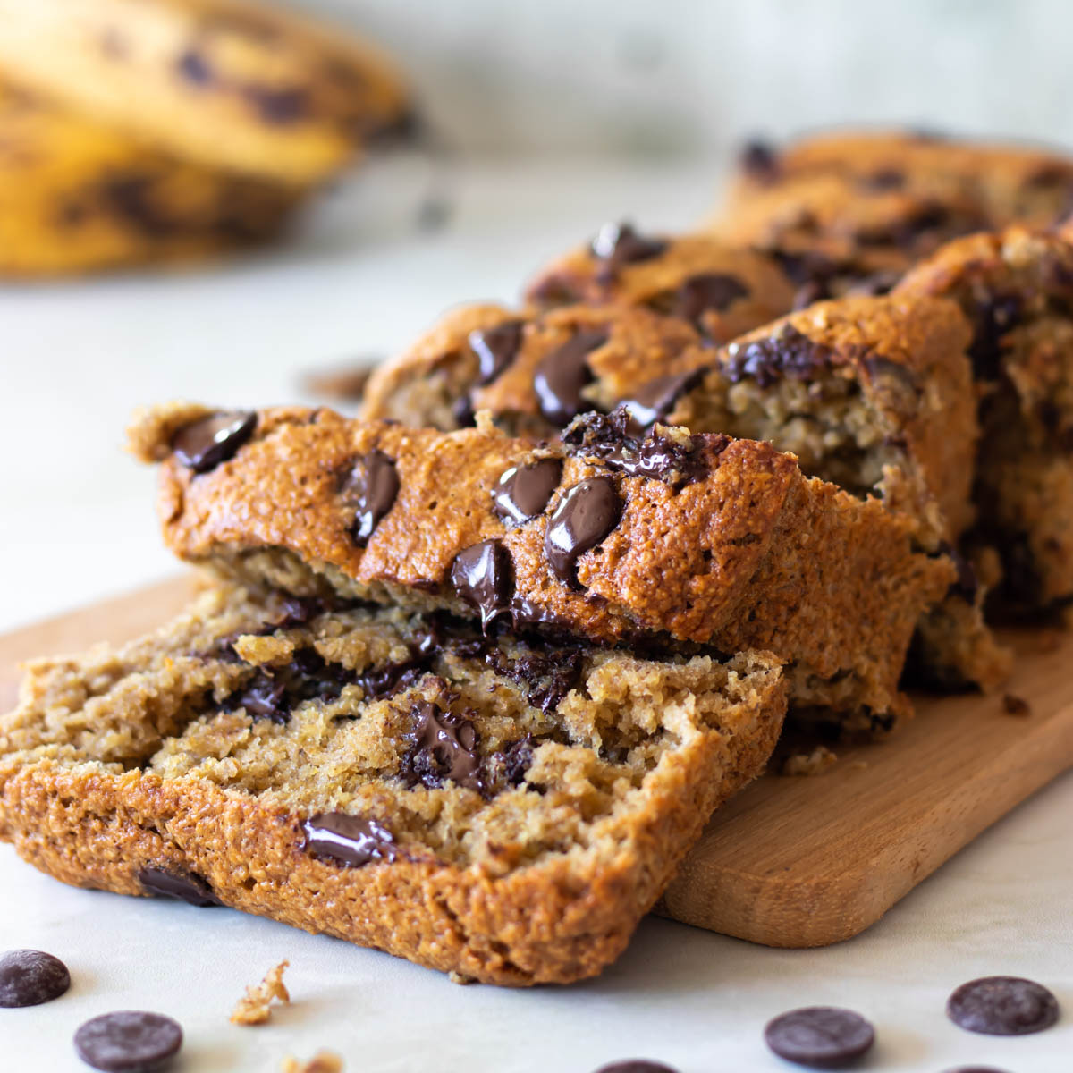 bolo de banana com gotas de chocolate cortado em cima de uma tábua