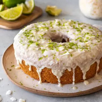 bolo de coco e limão com cobertura de manteiga de coco integral, coco em fitas e raspas de limão servido em um prato