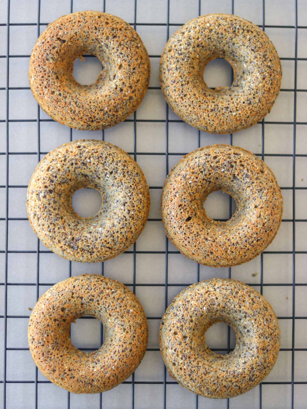 seis donuts de aveia e chia em uma grade de resfriamento
