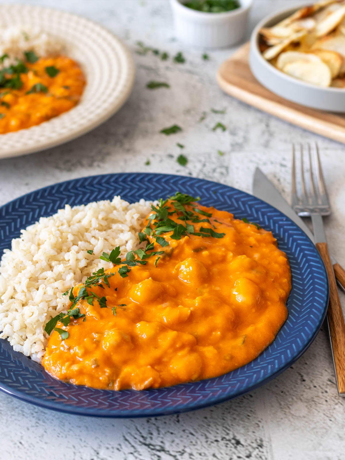 estrogonofe de grão-de-bico vegano servido num prato com arroz integral e salsinha fresca picada