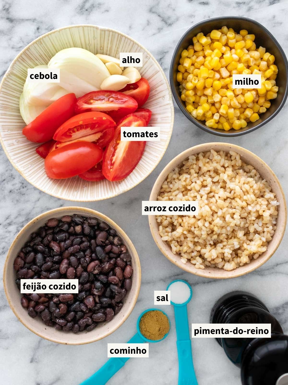 ingredientes para fazer prato de arroz com feijão ao molho de tomate, incluindo cebola, tomate, alho, cominho em pó, sal, pimenta-do-reino moída, milho, feijão cozido e arroz cozido