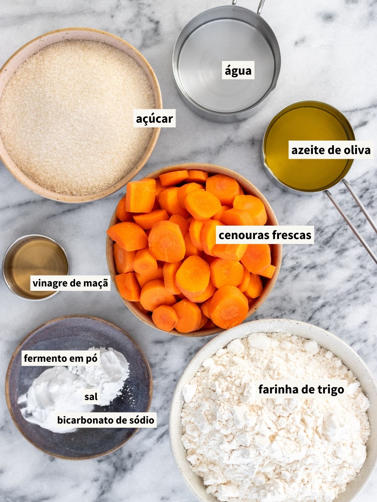 ingredientes para fazer bolo de cenoura vegano, incluindo cenouras, açúcar cristal, azeite de oliva, água filtrada, vinagre de maçã, sal, farinha de trigo, fermento químico em pó e bicarbonato de sódio