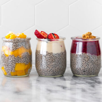 pudim de chia servido com três diferentes acompanhamentos: 1) manga fresca em cubos e coco ralado, 2) iogurte com morangos e mirtilos frescos, 3) geleia de morango com granola caseira