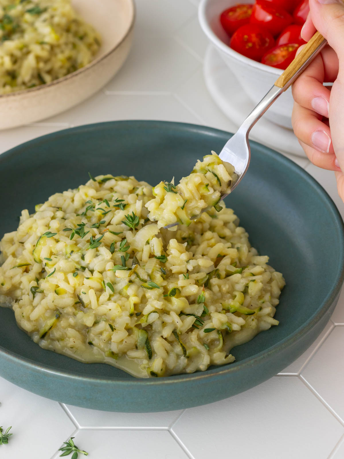 garfo retirando uma porção de risoto de abobrinha com tomilho de um prato, mostrando sua cremosidade