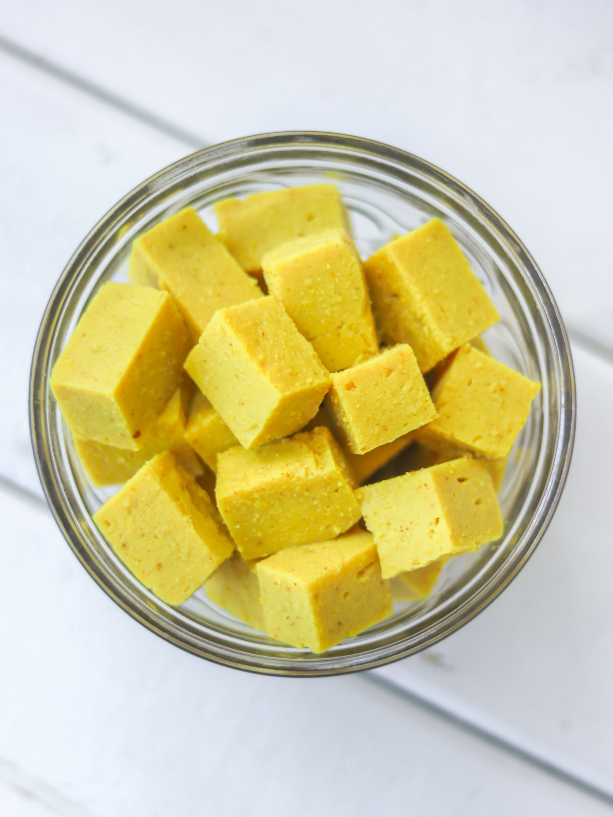 cubinhos de tofu de grão-de-bico crus dentro de um pote de armazenamento