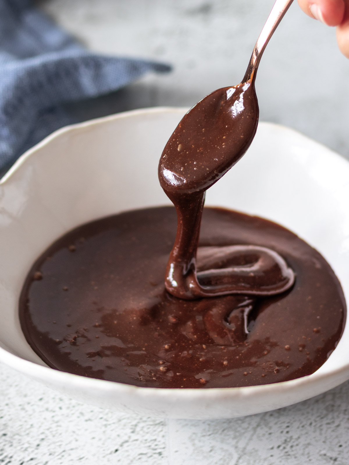 colher sendo retirado de tigela de brigadeiro vegano, mostrando sua textura cremosa