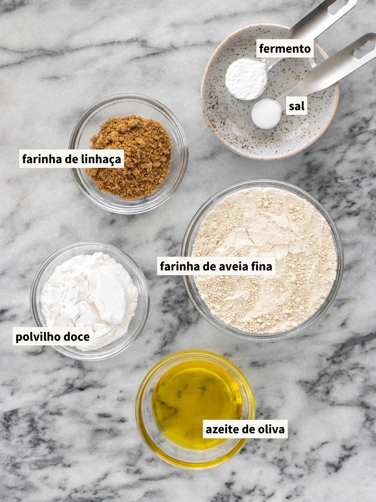 ingredientes para fazer massa de pizza de aveia, incluindo farinha de aveia fina, polvilho doce, farinha de linhaça, fermento químico em pó, sal, água morna e azeite de oliva