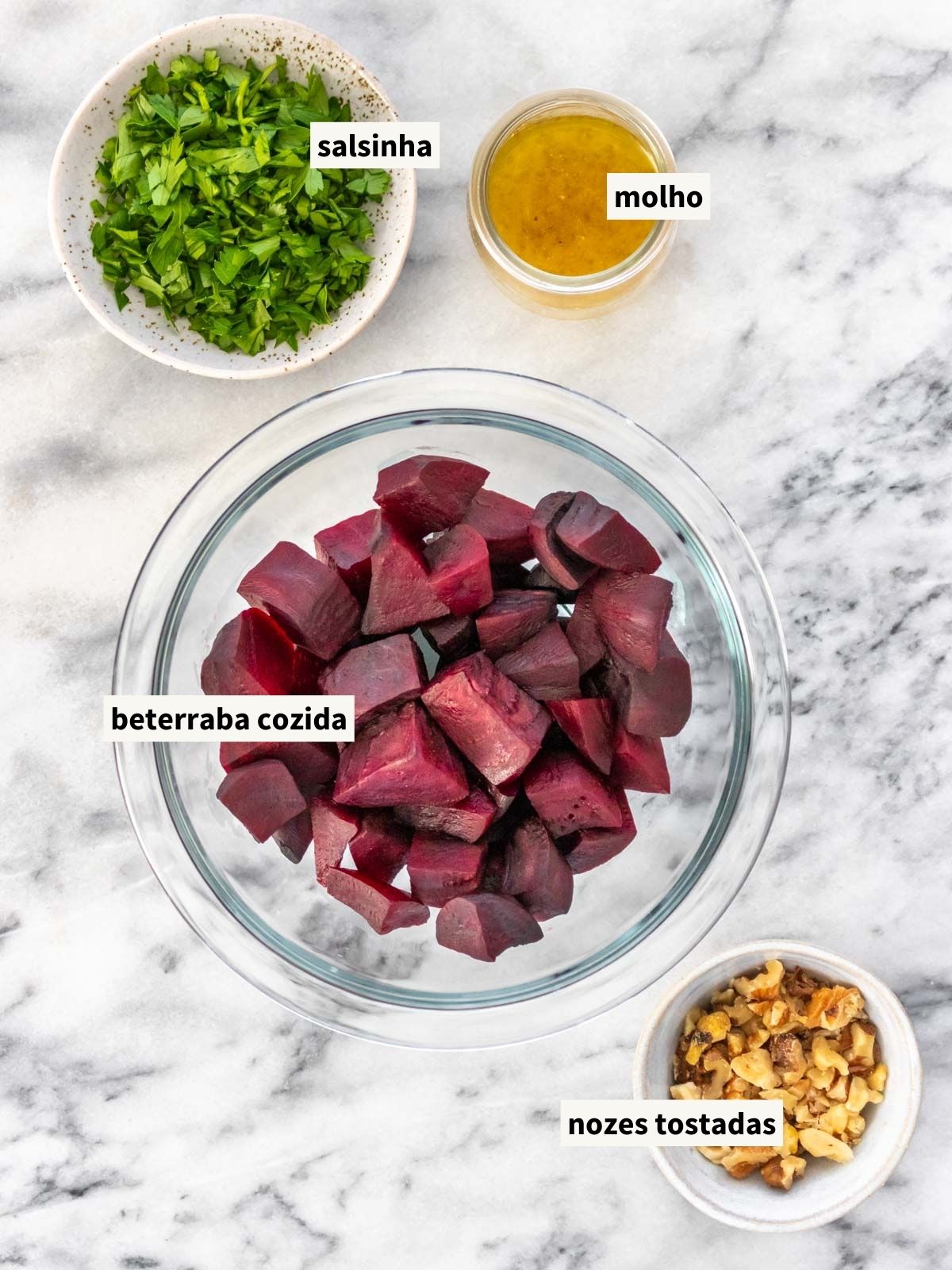 ingredientes para fazer salada de beterraba cozida, incluindo beterraba cozida, salsinha fresca, nozes chilenas e molho feito de suco de limão-taiti, azeite de oliva, sal, pimenta-do-reino moída e alho